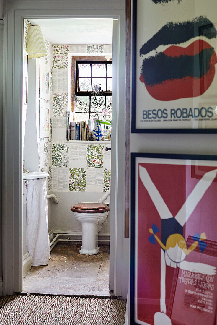 Gerahmte Drucke im Flur mit Blick auf ein tapeziertes Badezimmer in einem Bauernhaus in Oxfordshire, UK