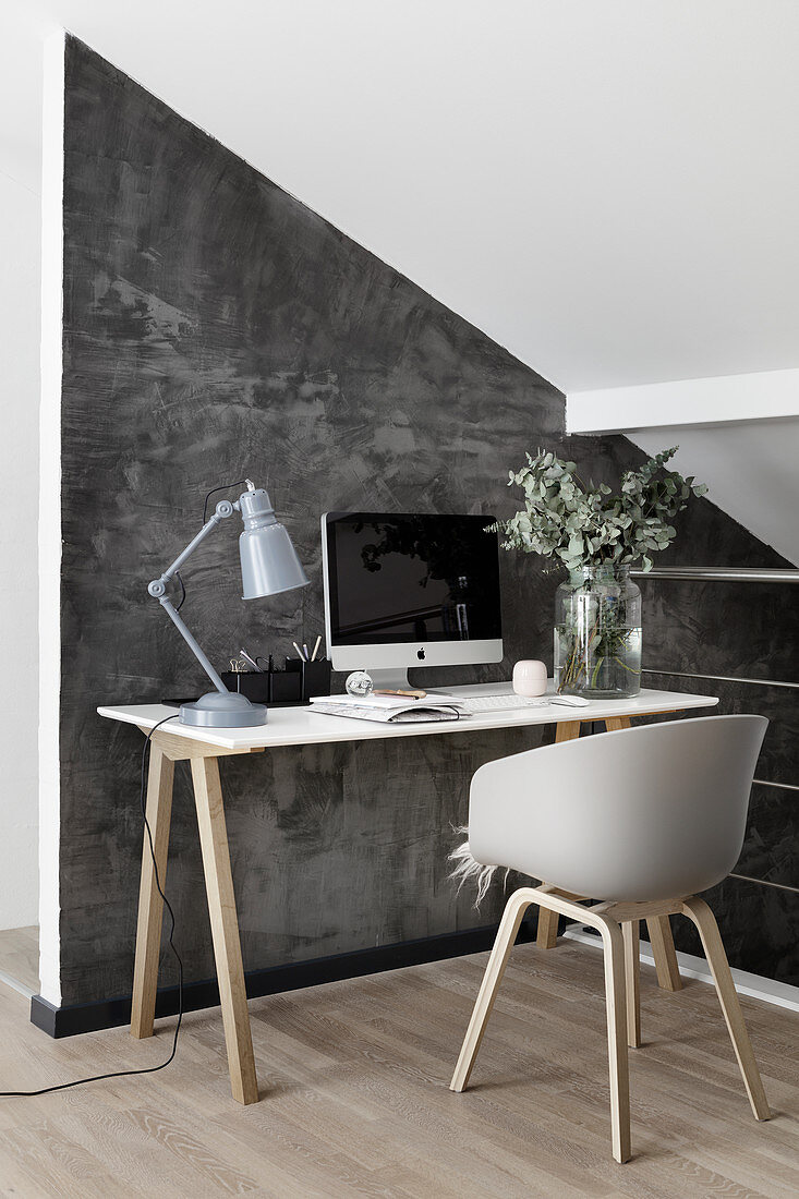 Schreibtisch im Skandinavischen Stil vor grauer Wand unter der Schräge