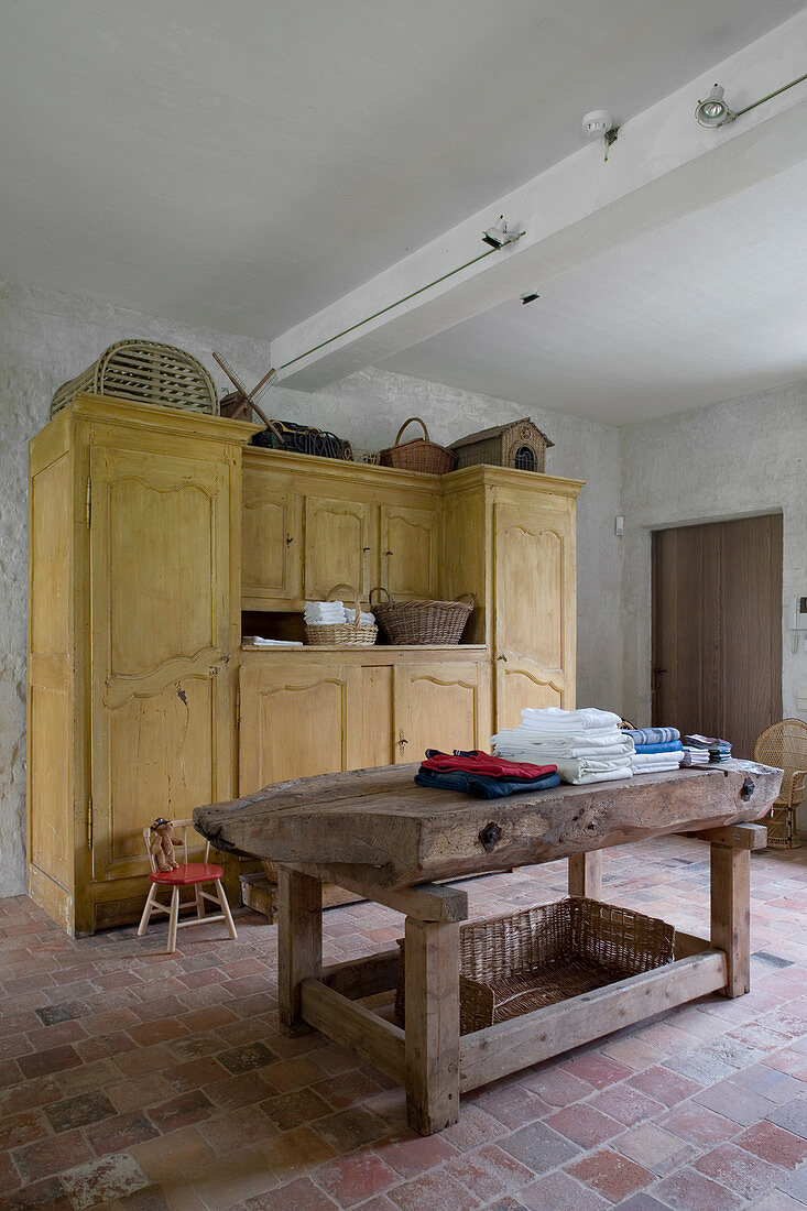 Old workbench and yellow cupboard in rustic laundry room