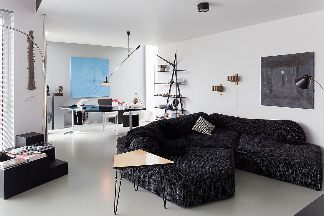 Designersofa und Schreibtisch im Wohnzimmer in Schwarz-Weiß
