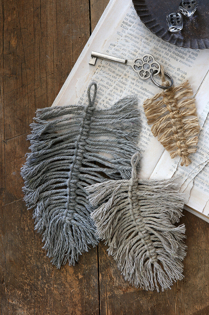 Woollen macrame feathers used as key pendants on old book