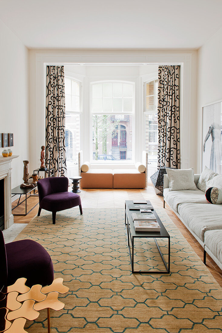 Elegantes Wohnzimmer mit grafisch gemustertem Teppich und Vorhang