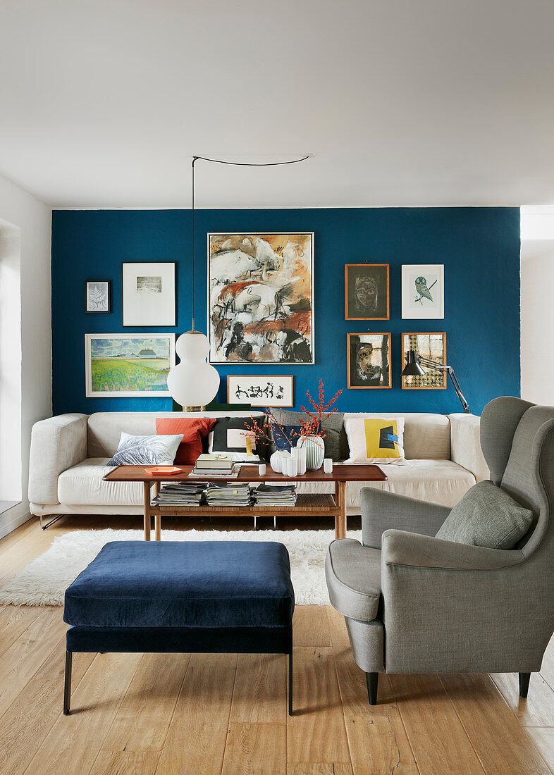 Bildergalerie an blauer Wand im klassischen Wohnzimmer