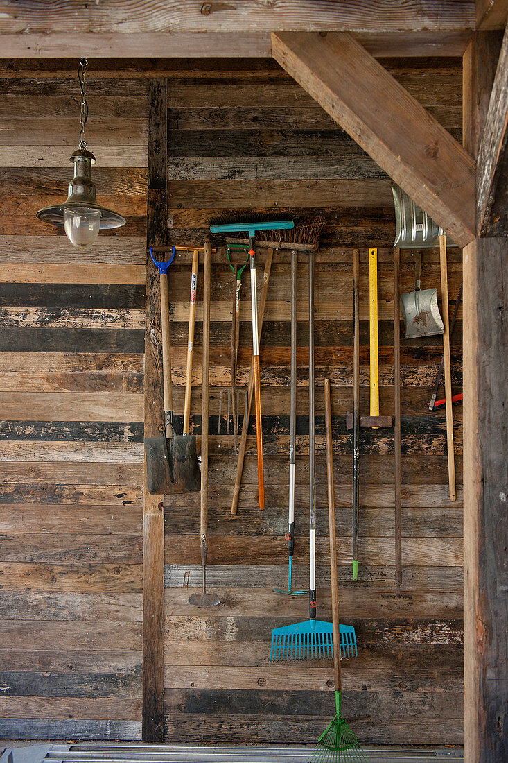 Gardening tools hung on board wall made from reclaimed wood