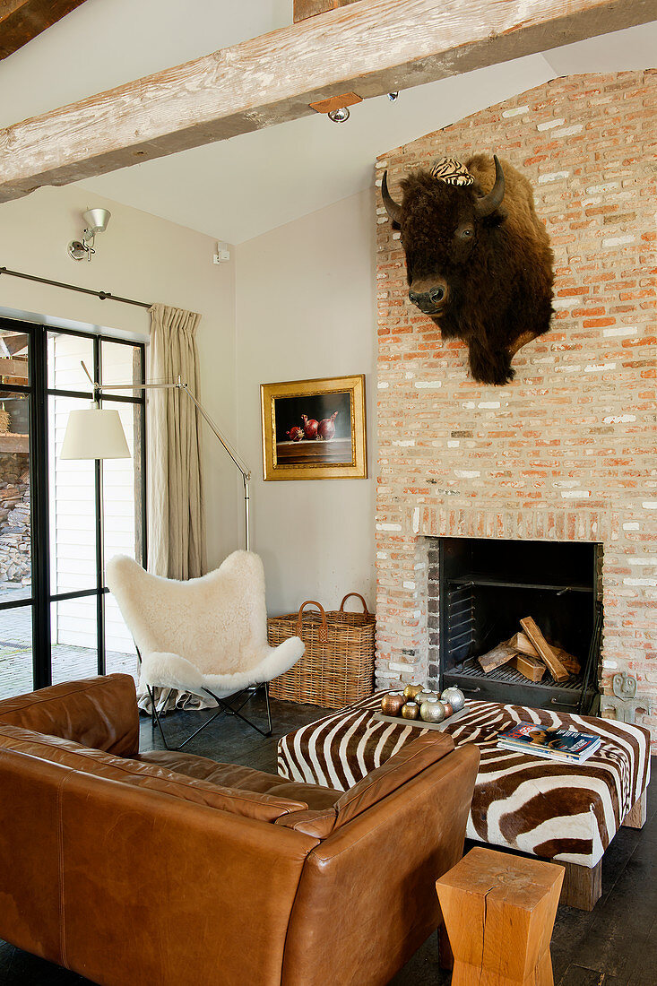 Buffalo head above open fireplace in rustic living room