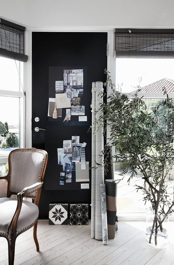 Barockstuhl, schwarze Pinnwand an der Tür und Bodenvase mit Olivenzweigen im Arbeitszimmer