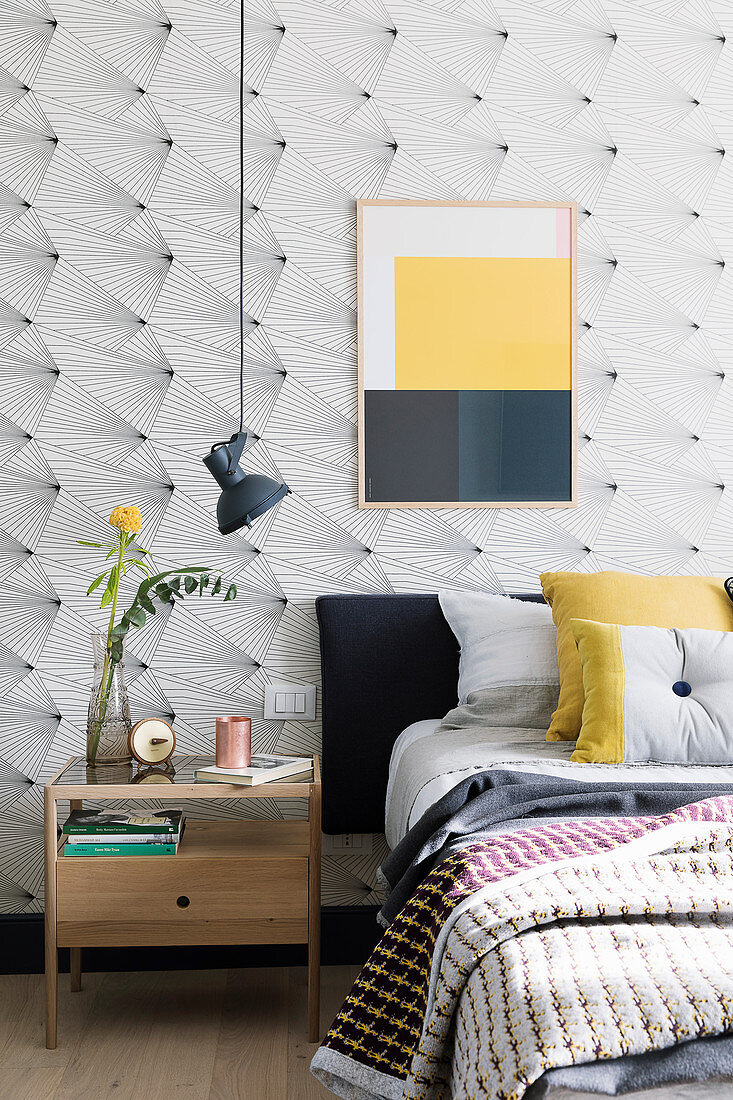Picture with blocks of colour on wallpaper with graphic pattern in bedroom