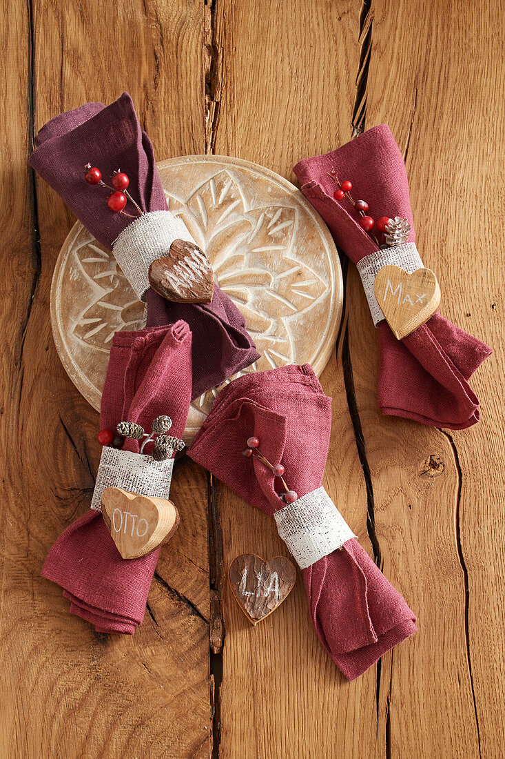 Linen napkins with napkin rings and names on wooden hearts