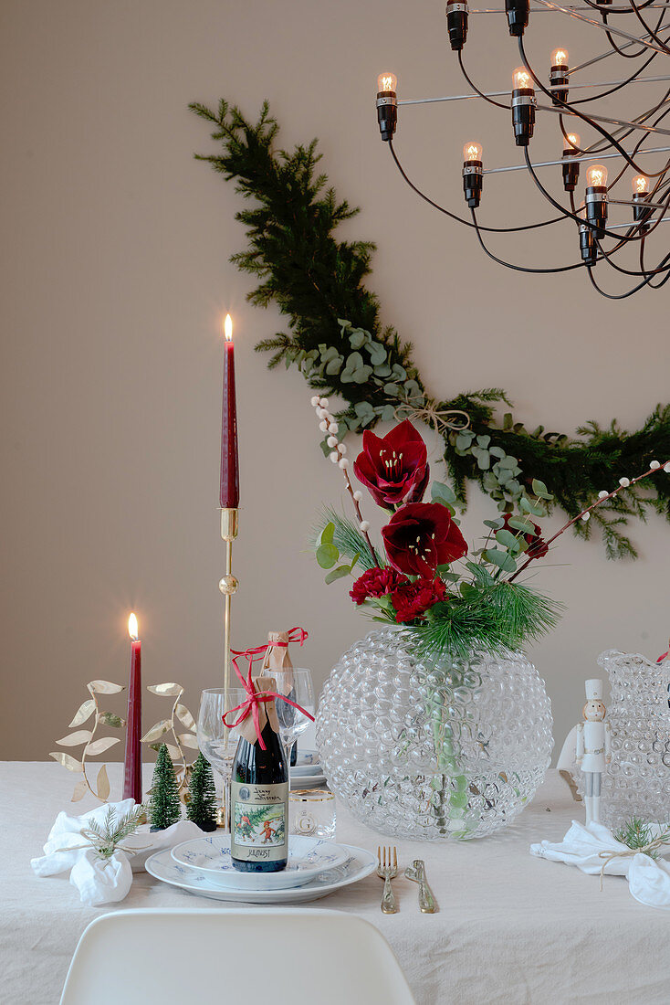 Table festively set for Christmas with red candles and amaryllis