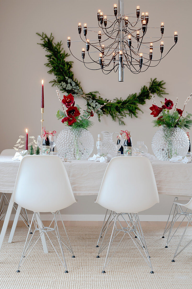 Designer chairs around table set for Christmas decorated with amaryllis