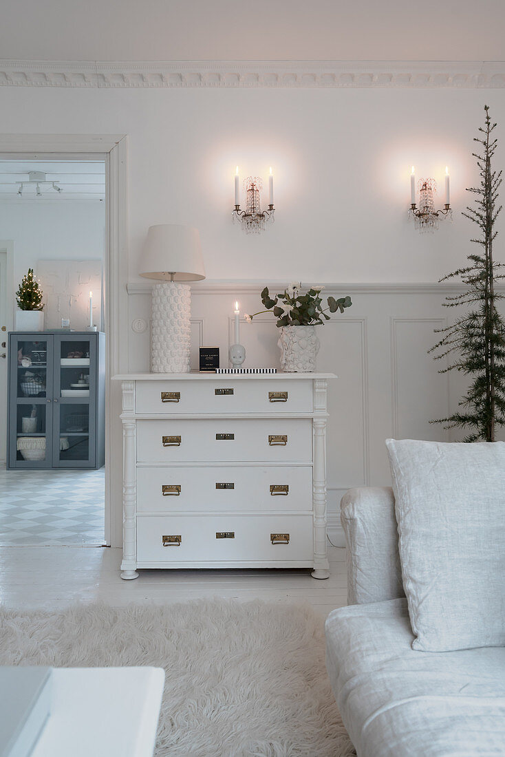 Antique chest of drawers in white living room with wintry decorations