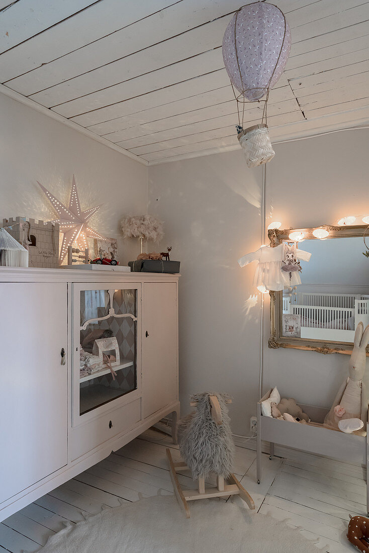 Antique sideboard in vintage-style nursery decorated in grey