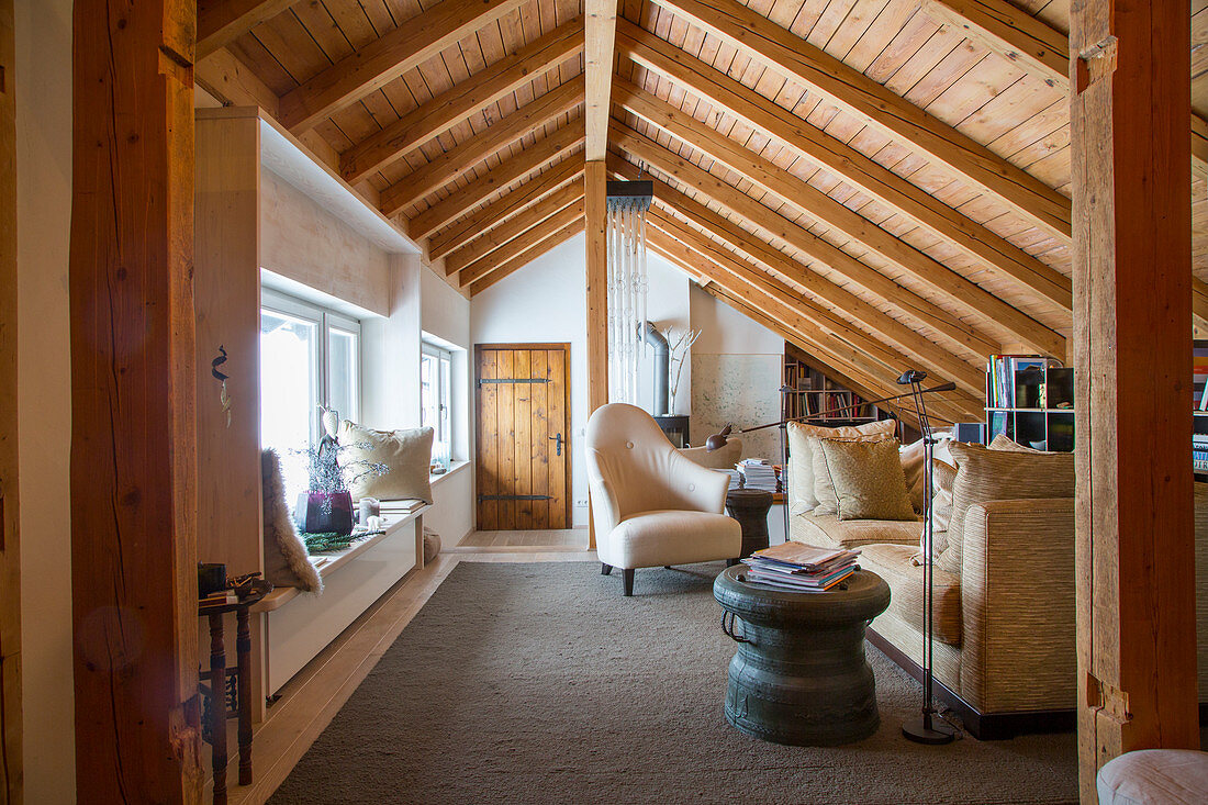 Rustikales Wohnzimmer unter der Dachschräge mit Holzverkleidung
