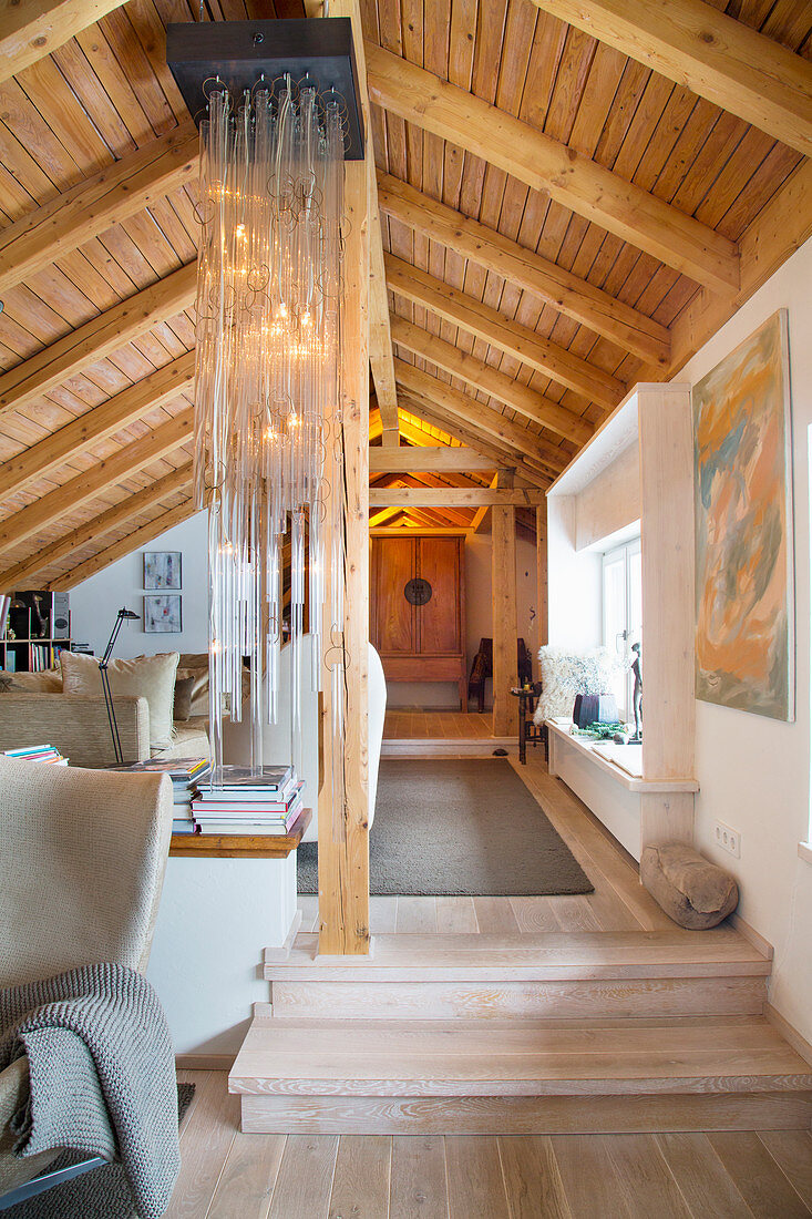 Rustic living room under sloping, wood-clad ceiling