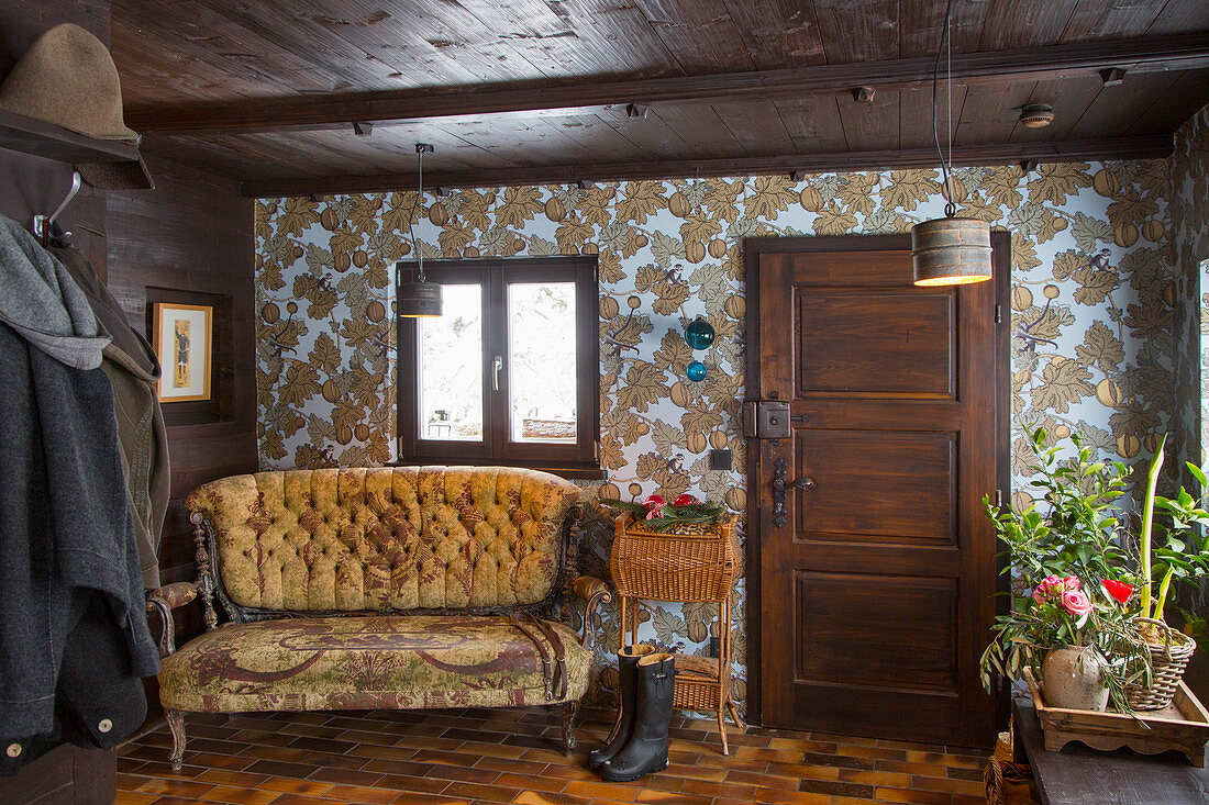 Rustic foyer with dark wooden ceiling and vintage-style wallpaper