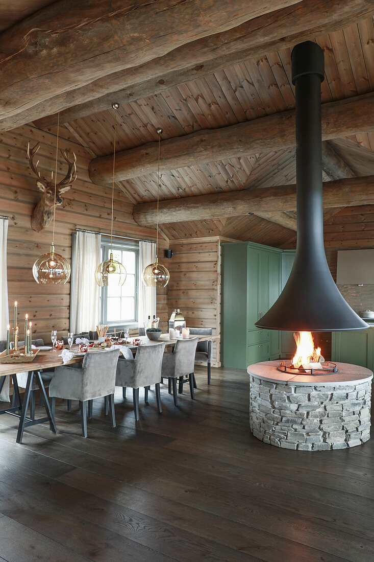 Open fire and country-house kitchen in rustic dining room