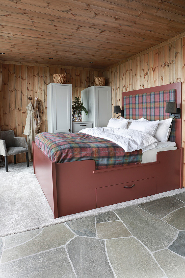 Rustikales Schlafzimmer mit Natursteinboden und Holzverkleidung