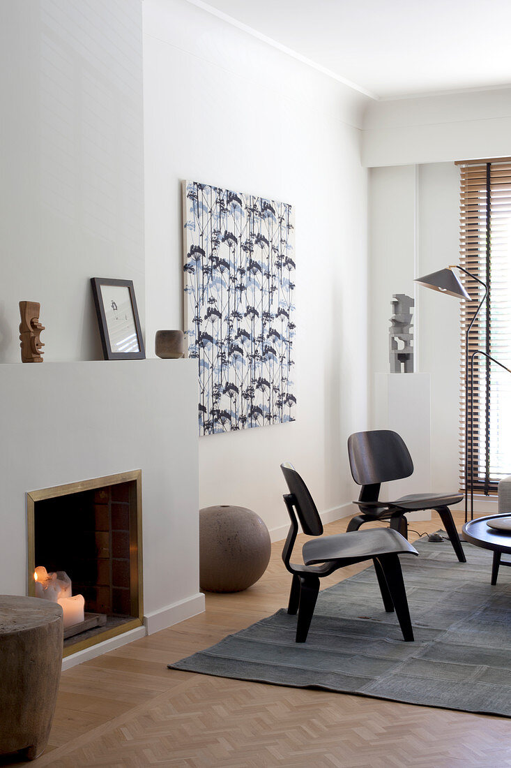 Designerstühle vorm offenen Kamin im künstlerischen Wohnzimmer