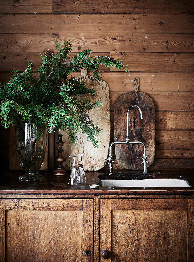 Rustikaler Küchenunterschrank mit Spülbecken, Tannenzweige in Vase