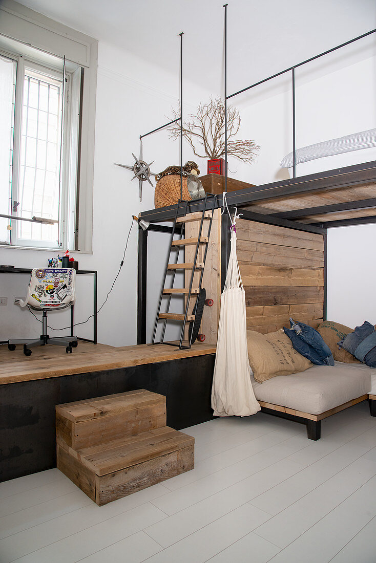 Sofa mit Kissen unter Galerieebene in Loftwohnung im Industriestil