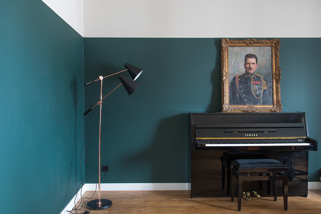 Piano and stool below portrait