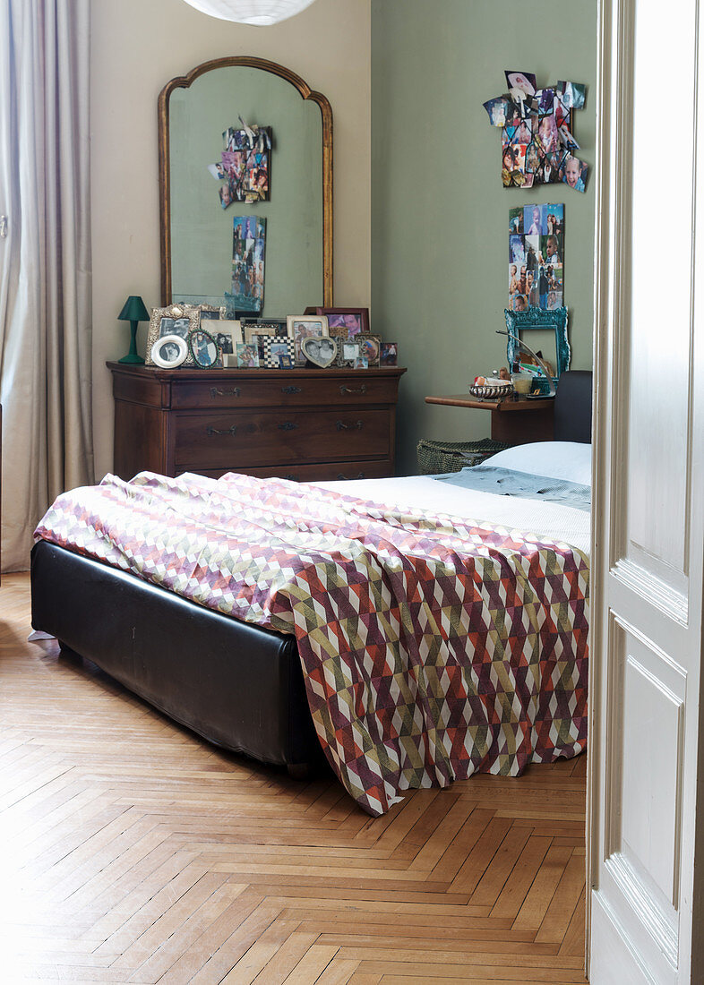 Doppelbett und antike Kommode mit Spiegel im Schlafzimmer