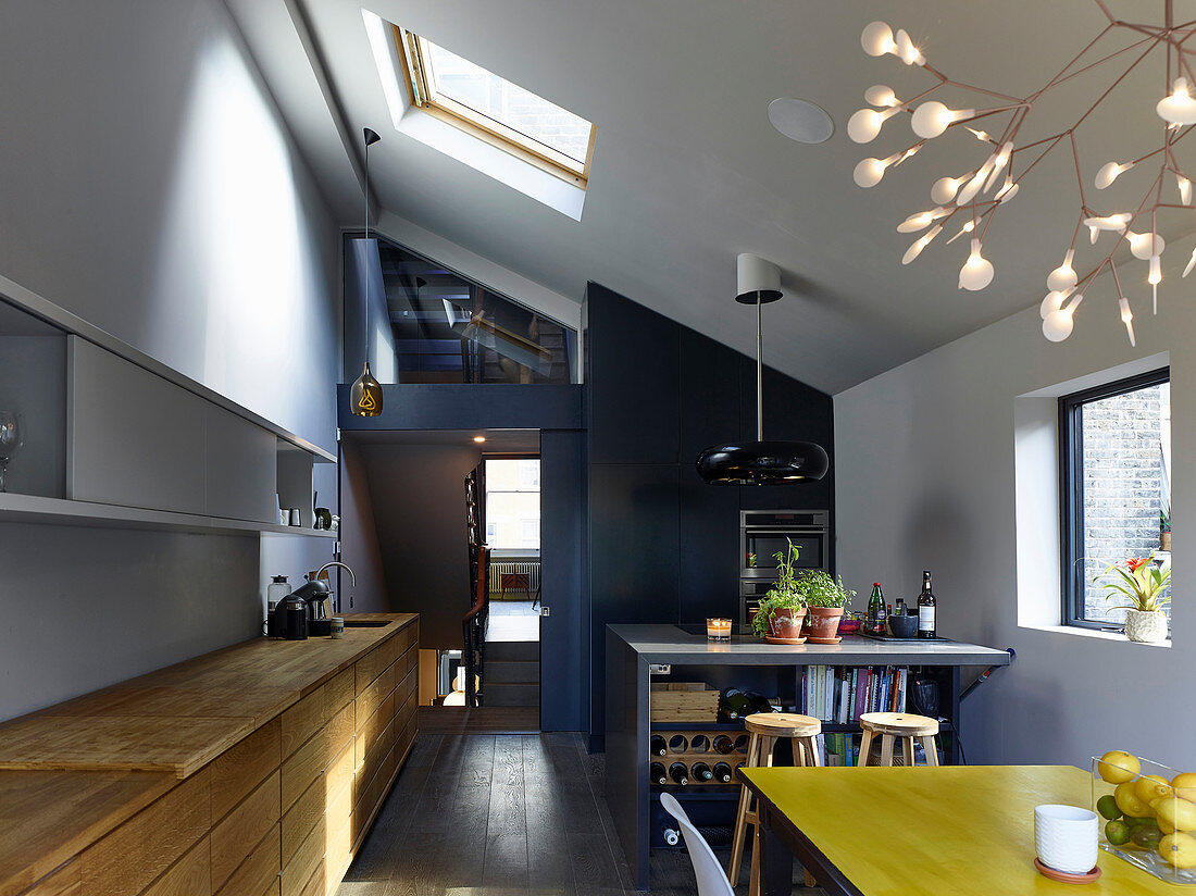 Moderner Wohnraum mit offener Küche, Esstisch und hoher Decke