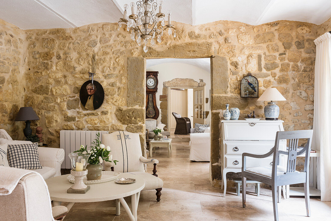 French travertine floors, bureau, stone walls and seating area in living room