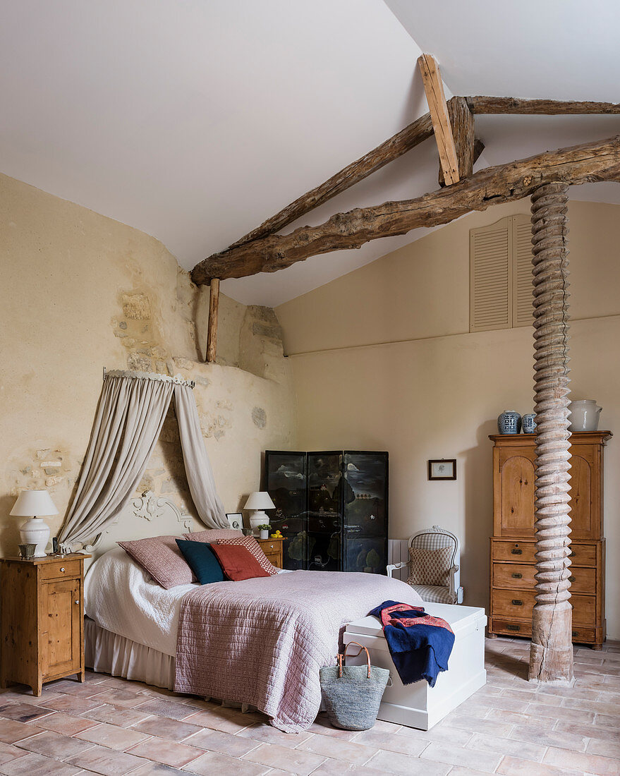 Alte Eichenölpresse im Hauptschlafzimmer mit Holzmöbeln und Paravent