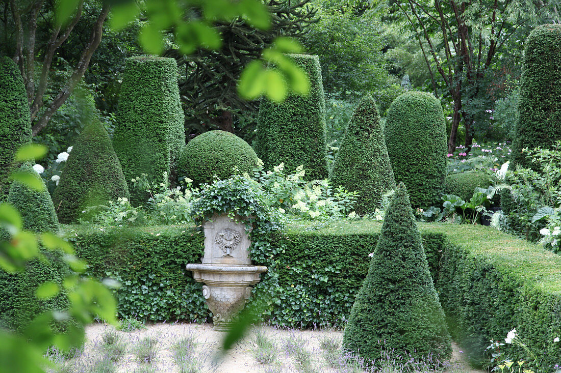 Box trees around lion waterspout in formal garden in Jardin Agapanthe, Normandy, France
