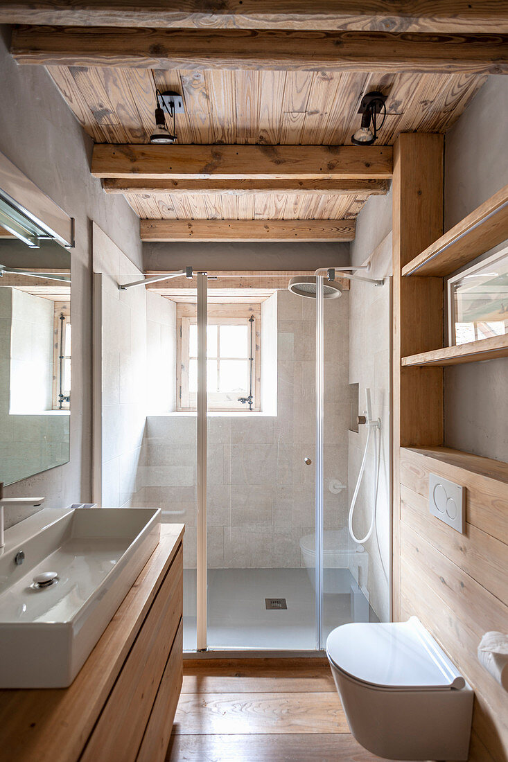 Badezimmer mit Holzmöbeln, Designer-Waschbecken und Duschbereich