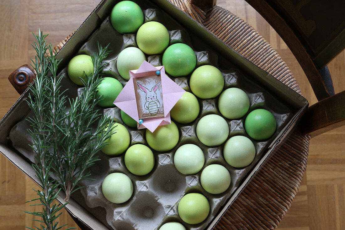 Kleines Ostergeschenk auf einem Eierkarton mit grünen Ostereiern