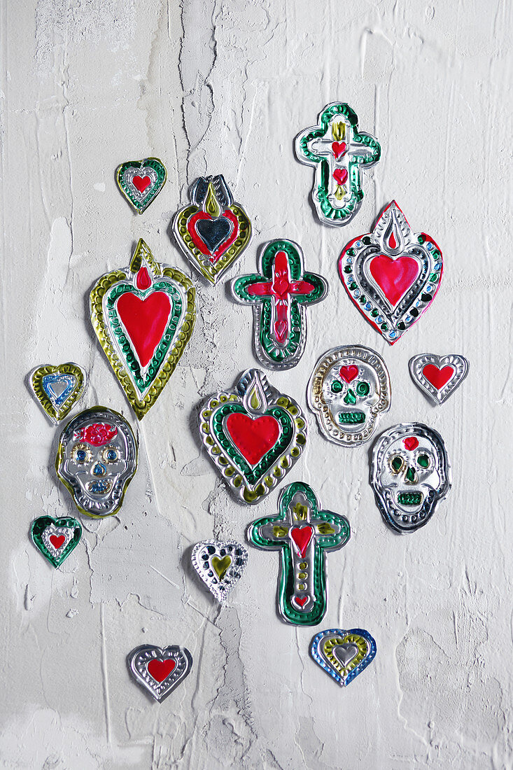 Handmade votive gifts made from embossed foil shaped like hearts, crosses and skulls