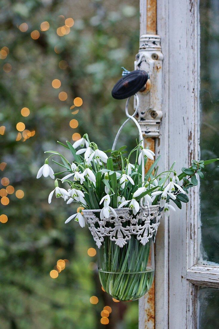 Posy of snowdrops in vintage-style glass vase