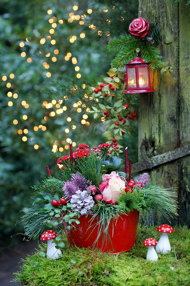 Festive arrangement in red and green with roses and fly agaric mushroom ornaments