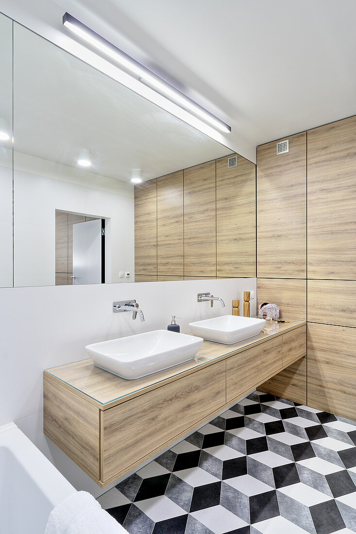 Floor with graphic pattern in bathroom with mirrored wall