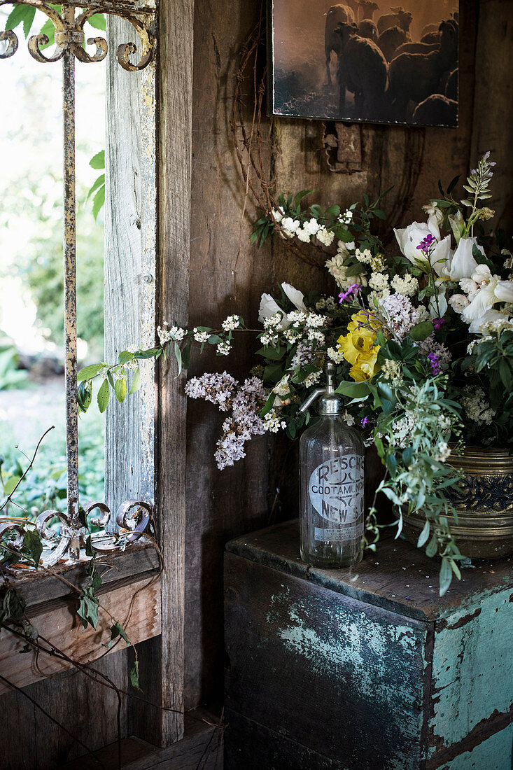 Strauß aus blühenden Gartenblumen auf alter Kommode in Bauernhaus