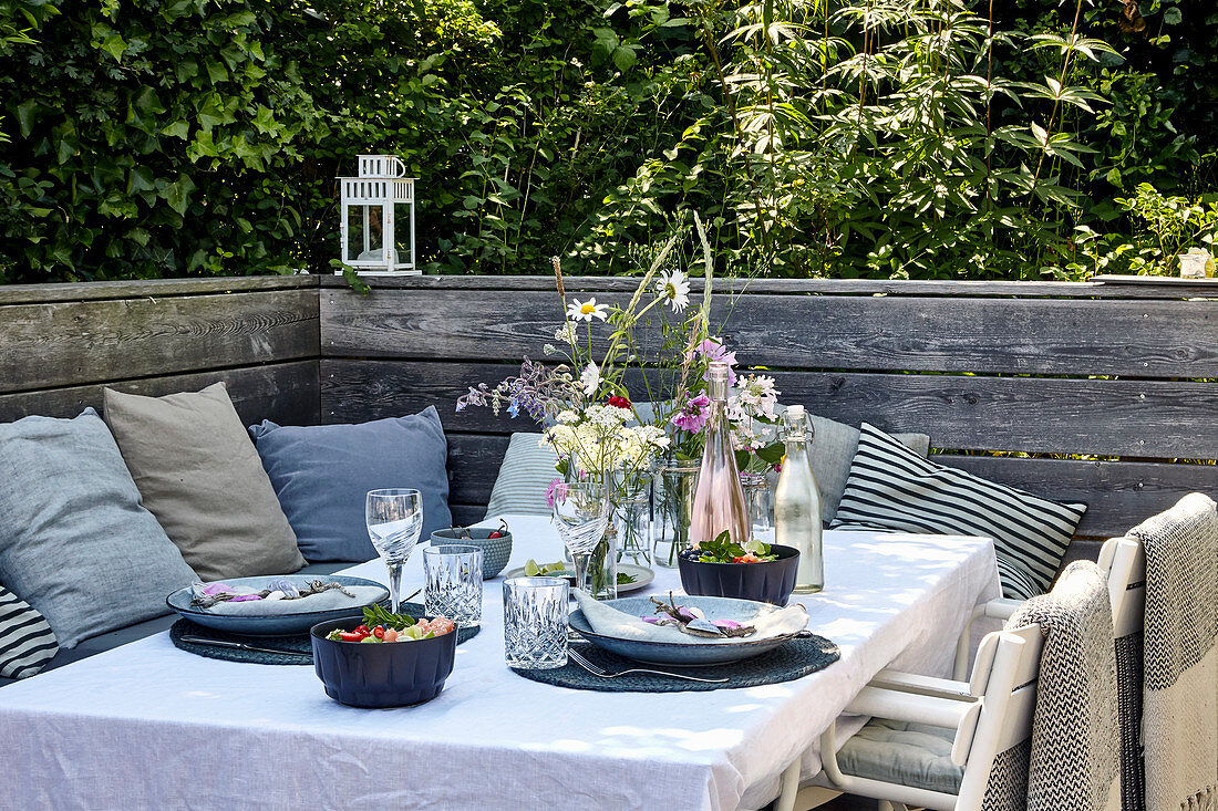 Sommerlich gedeckter Tisch auf Terrasse