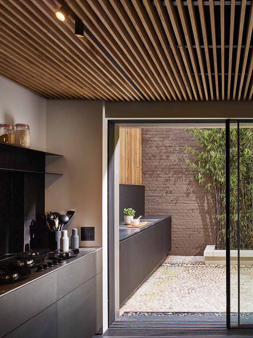 Moderne Küchenzeile setzt sich auf der Terrasse im Innenhof fort