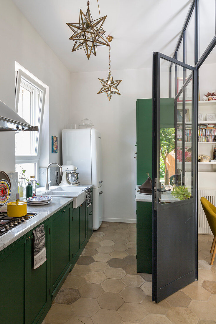 Schmale Küche mit dunkelgrünen Fronten und Wabenfliesenboden