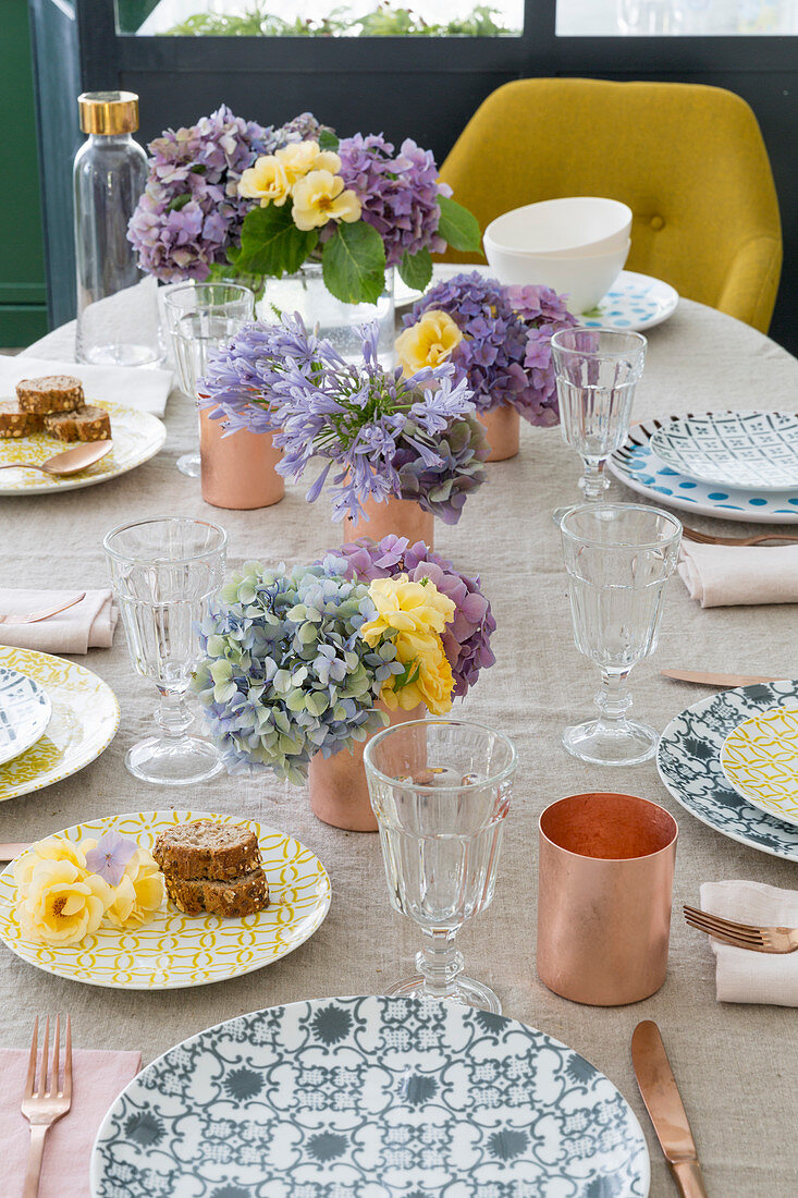 Patterned plates and flowers on table set for summer meal