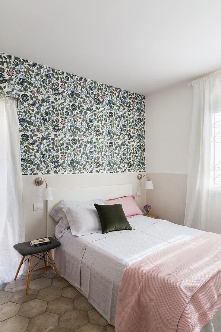 Floral wallpaper above beige painted dado in bedroom