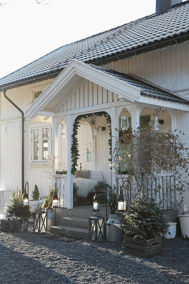 Holzhaus mit weihnachtlich dekoriertem Eingangsbereich