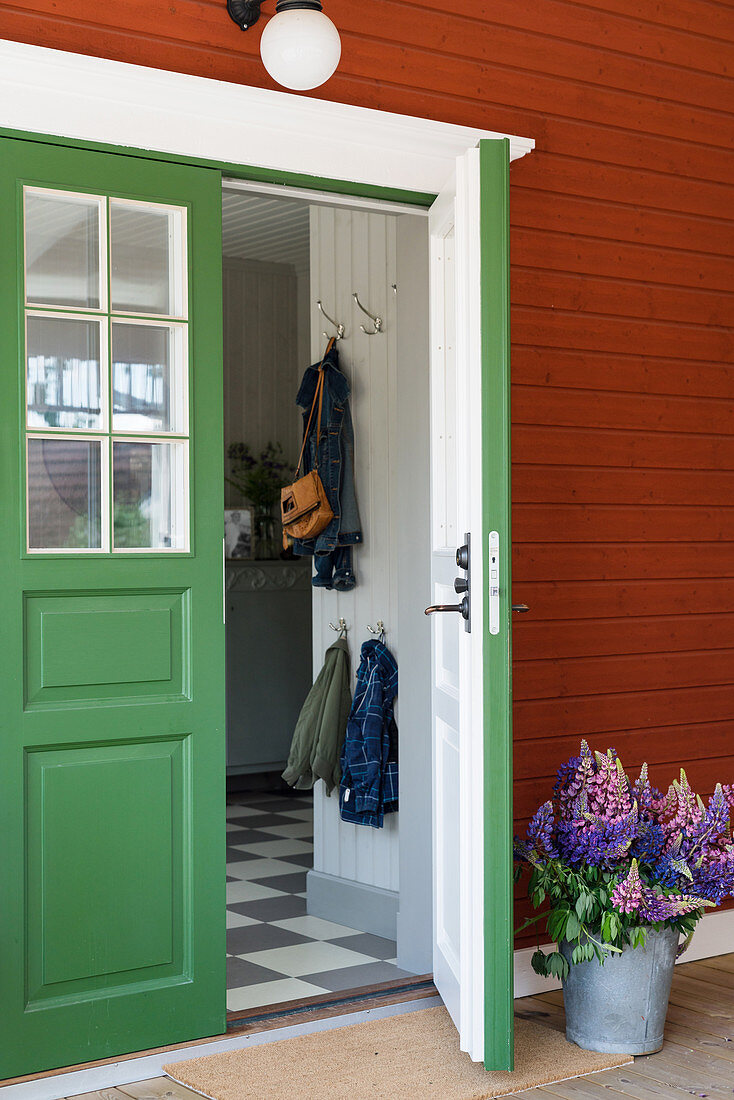 Rotbraunes Holzhaus mit grüner Tür