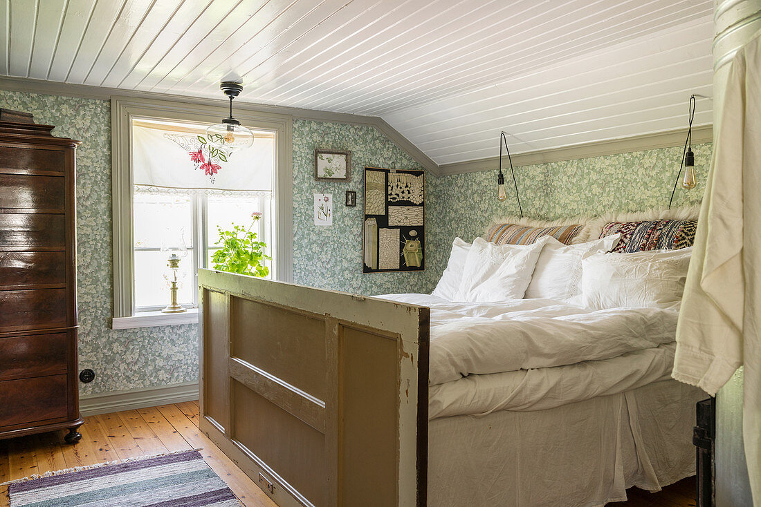 Selbst gebautes Bett aus recyceltem Material im Schlafzimmer mit Tapete