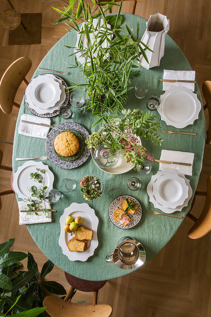 Mediterran gedeckter Tisch mit blassgrüner Tischdecke