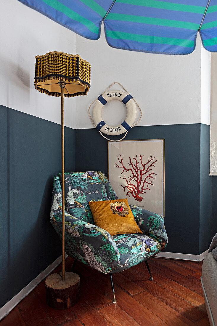 Sessel und maritime Deko an halbhoch blau gestrichener Wand