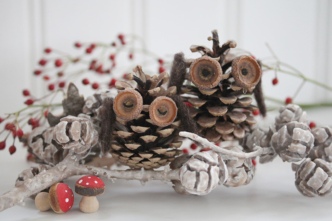 Owls handcrafted from pinecones and acorn cups decorated with waxed pine cones and miniature fly agarics