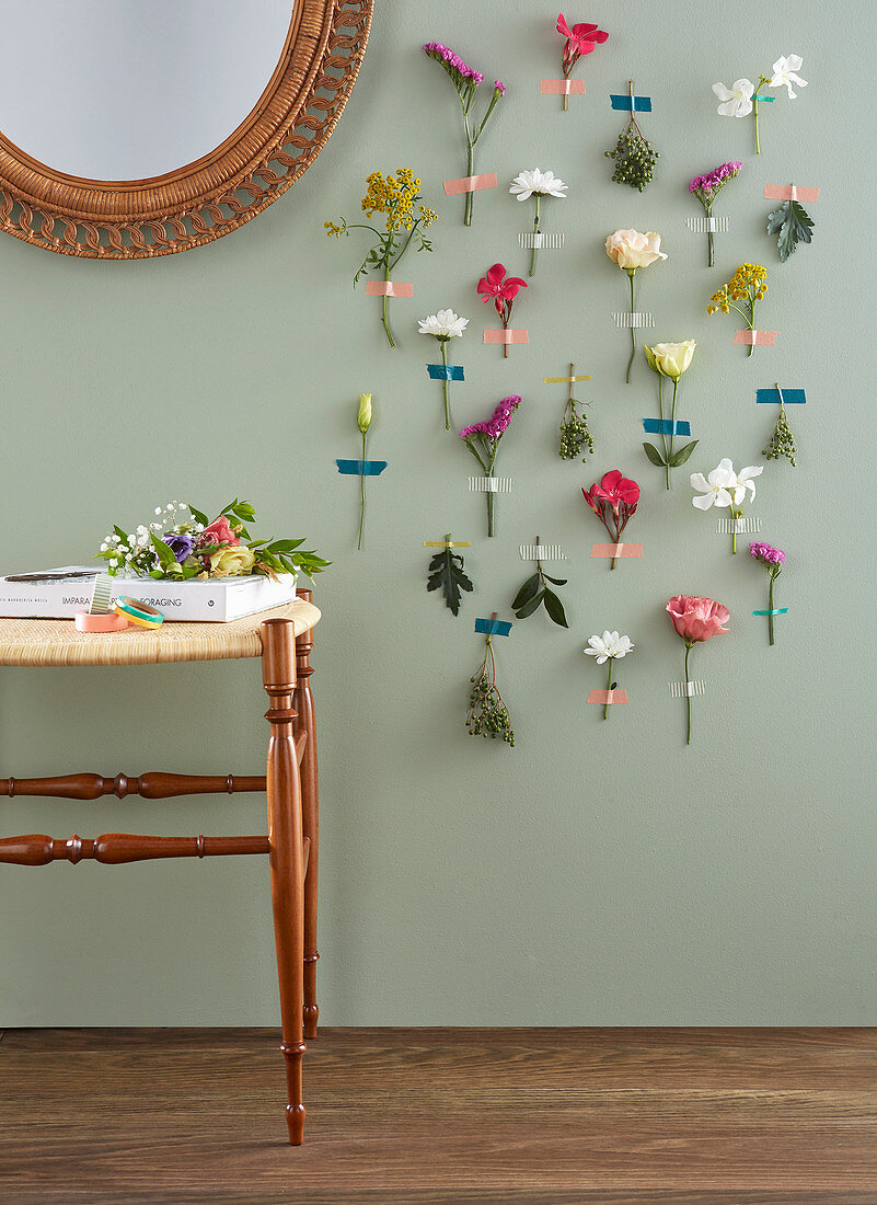 Various flowers stuck on wall with masking tape