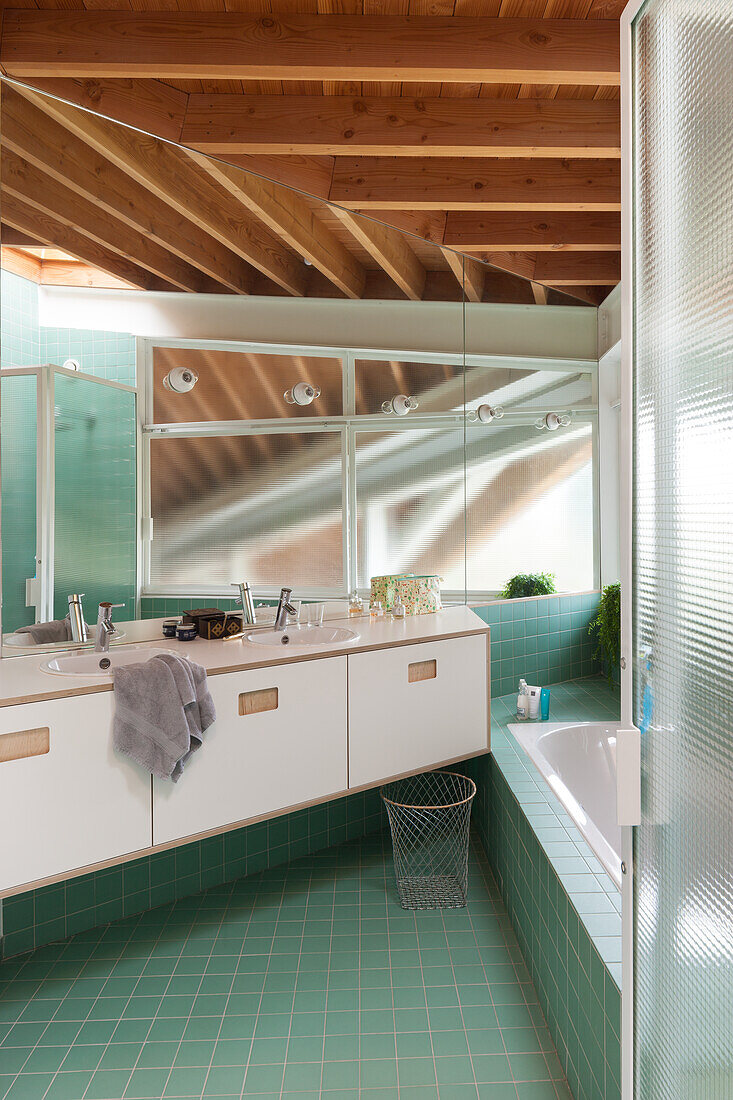 Bathroom with mint-colored tiles and wooden beamed ceiling